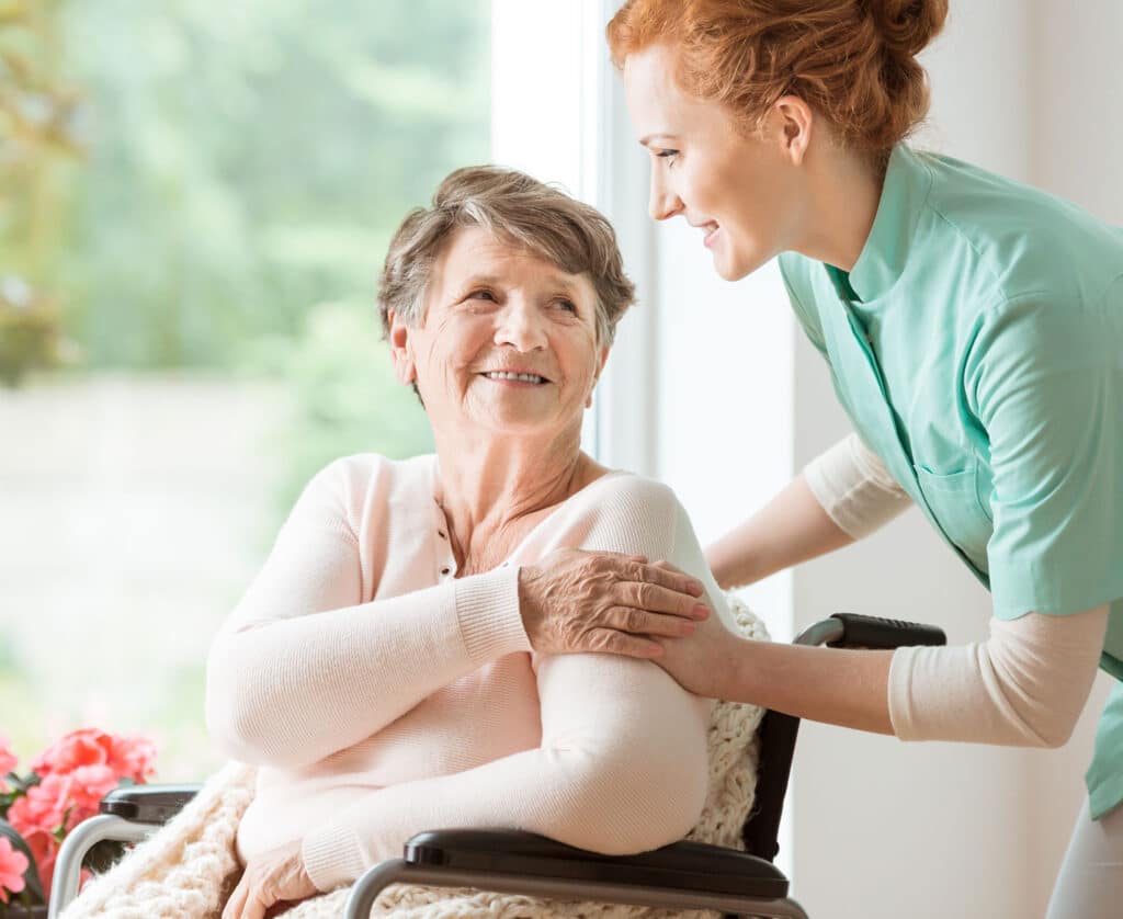 Nurse helping an elderly woman in a wheelchair